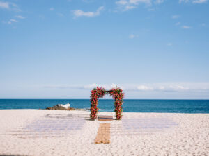 Mexico Destination Wedding, beach wedding ceremony, beachfront wedding ceremony setup, bright floral arbor