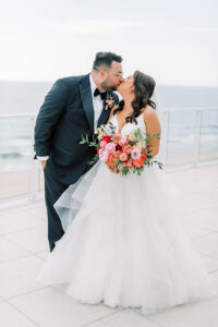 bride and groom kissing during wedding portraits on NJ rooftop wedding venue