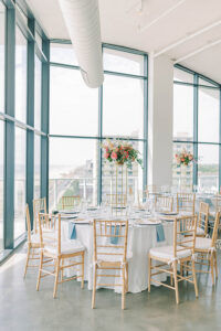 reception tables with colorful flowers on gold pedestals at Wave Resort