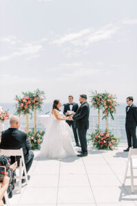 bride and groom holding hands during rooftop wedding ceremony