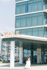 newlyweds in front of Wave Resort on wedding day