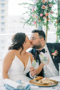 newlyweds kissing at sweetheart table during reception