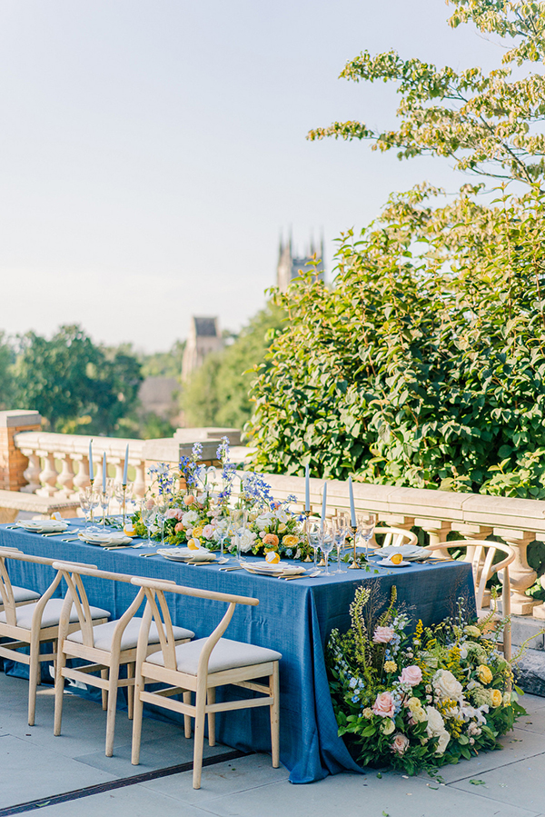 al fresco wedding tablescape with blue linen and colorful wedding centerpiece