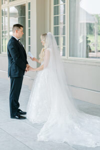 couple exchanging handwritten vows during first look at Alpine Country Club