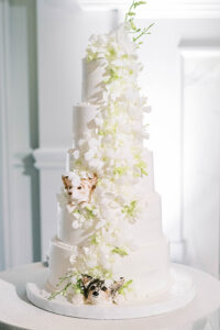 all white five-tier wedding cake including the couple's dogs