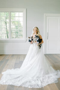 bride in Pnina Tornai gown holding dogs dressed in tuxedos