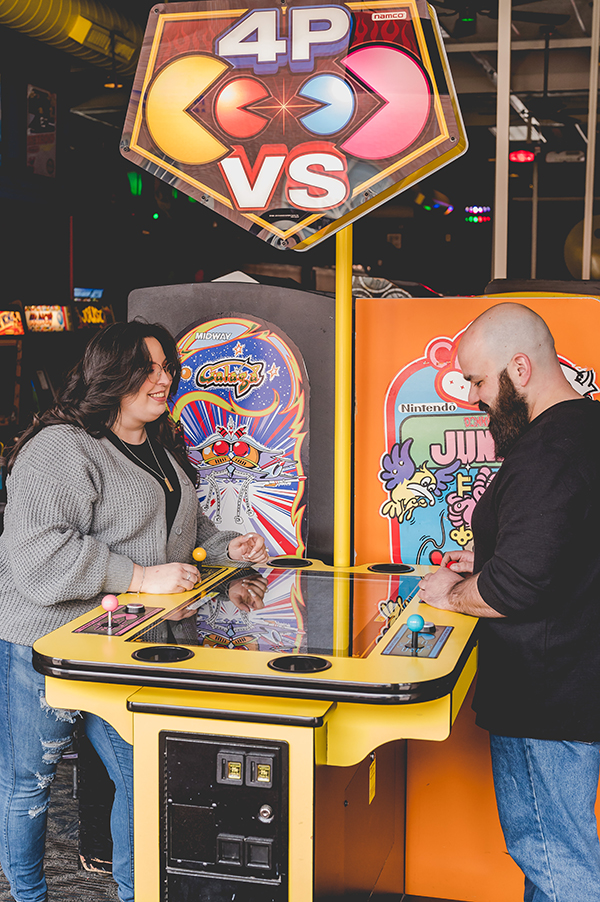 couple playing games at Yestercades during engagement session