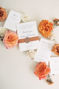 classic wedding invitation suite with terracotta ribbon and gold wax seal